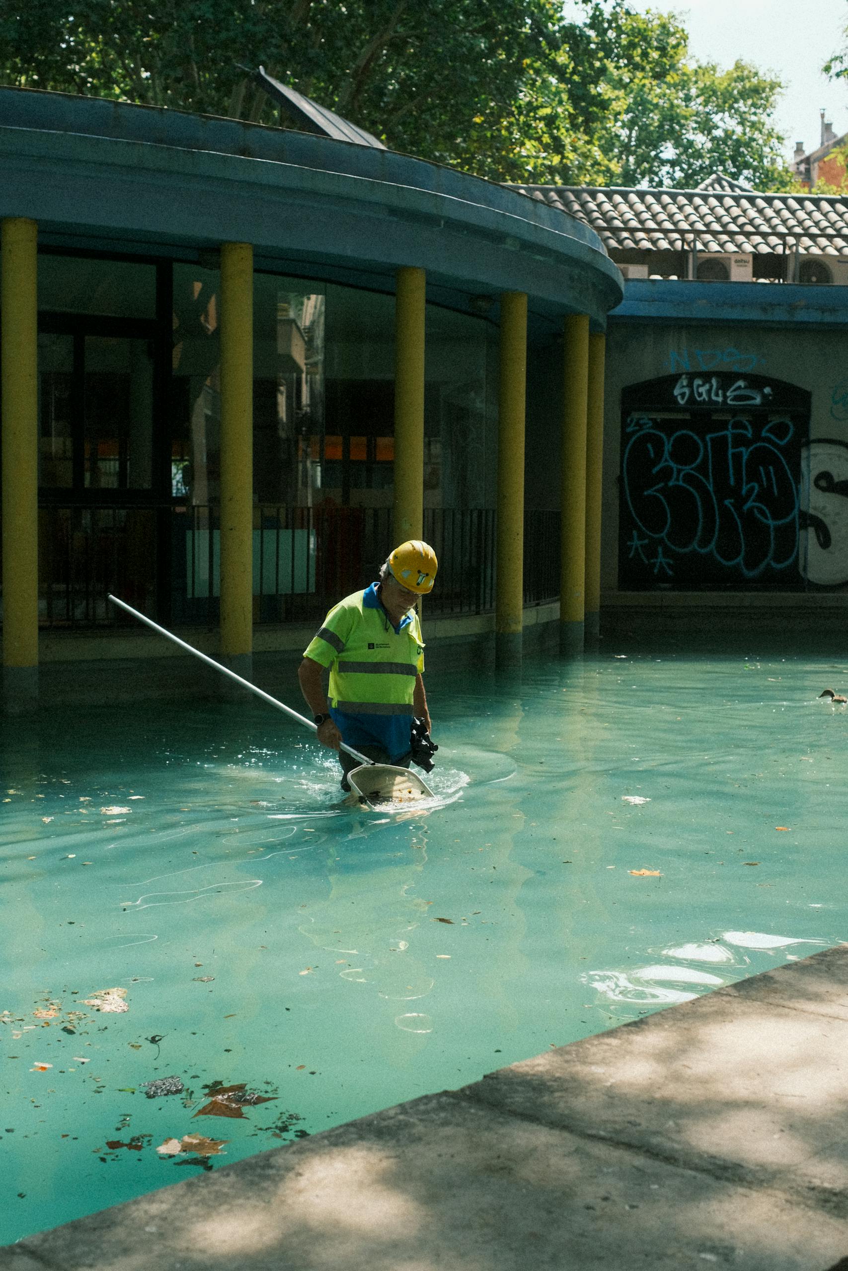 How to Find the Best Pool Cleaning Service Near Me in the USA How to Find the Best Pool Cleaning Service Near Me in the USA, A pool maintenance worker wearing safety gear cleans an outdoor pool in Barcelona, Spain.